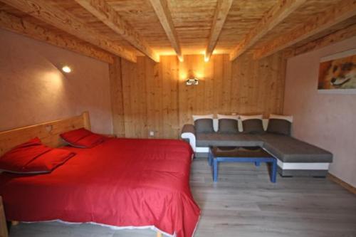 a bedroom with a red bed and a bench at Gîte du Poirier in Le Tholy