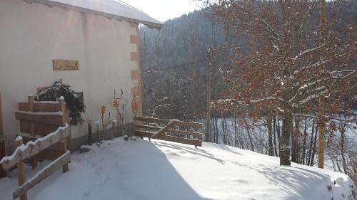 a snow covered balcony with a bench and a fence at Gîte du Poirier in Le Tholy