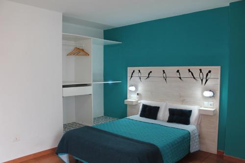 a bedroom with a blue wall with a bed at Hotel el Pino in Teror