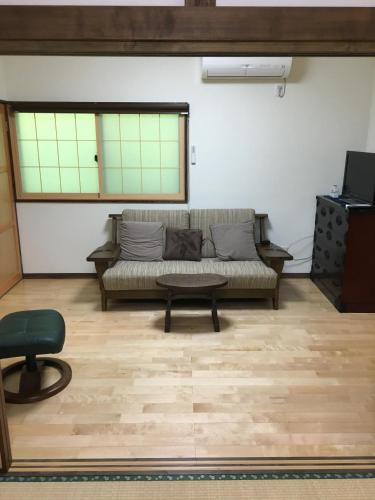 a living room with a couch and a table at Anzuan Nishida in Ueda