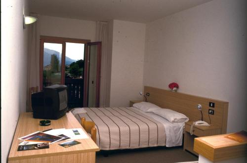 a small bedroom with a bed and a television at Hotel Cristina in Tenno