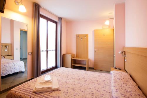 pokój hotelowy z 2 łóżkami i oknem w obiekcie Albergo Verdi w mieście Novi Ligure