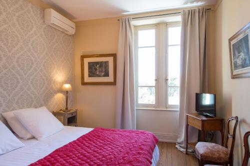 - une chambre avec un lit doté d'une couverture rouge et d'une fenêtre dans l'établissement La Maison d'Amédée, à Montségur-sur-Lauzon