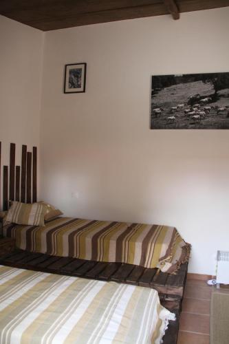 a bedroom with a bed and a picture on the wall at Couto dos Pardinhos in Monforte da Beira