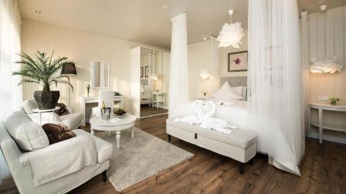 Hotel Grimsborgir by Keahotels في Ásborgir: غرفة معيشة مع أريكة بيضاء وكرسي