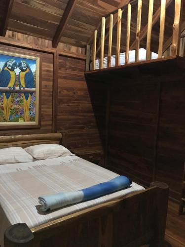 1 dormitorio con 1 cama en una habitación de madera en Hotel Cabanas La Teca, en Liberia