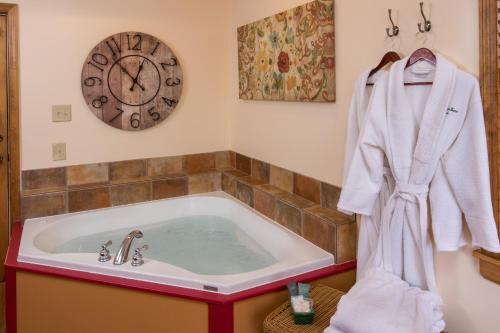 a bathroom with a bath tub with a clock on the wall at Farmers Guest House in Galena