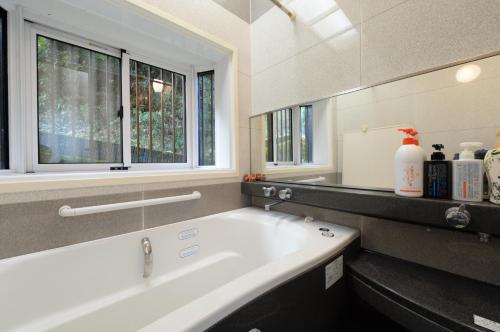 a white bath tub in a bathroom with a window at Guesthouse Kimiko in Kasagicho