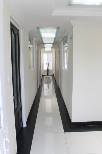 a corridor of an office building with white walls and a long hallway at Hotel Sweet Home in Bogotá