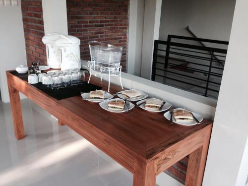 a wooden table with plates of food on it at Hastina Hotel Lombok in Mataram