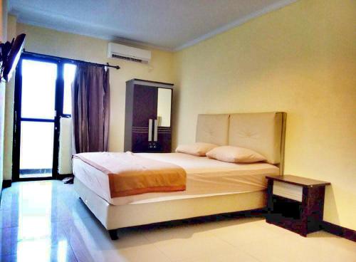 ein Schlafzimmer mit einem großen Bett und einem Fenster in der Unterkunft Quint Hotel in Manado