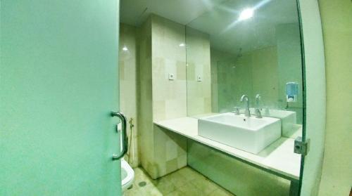 マナドにあるQuint Hotelのバスルーム(洗面台、鏡、トイレ付)