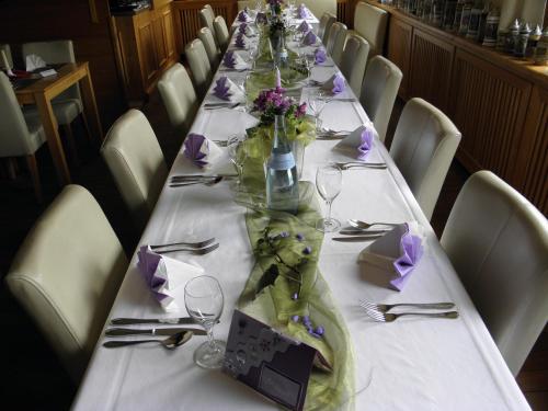 a long table with flowers and glasses on it at Alb Hotel Schalksburg in Albstadt