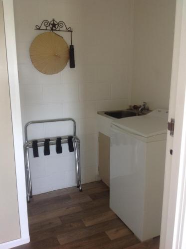 a laundry room with a sink and a washing machine at Panorama Heights Apartment in Paihia
