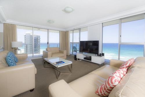 a living room with a couch and a television at Sunbird Beach Resort Gold Coast in Gold Coast