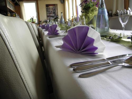 a table with purple napkins and silverware on a table at Alb Hotel Schalksburg in Albstadt