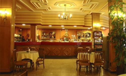 a restaurant with a bar and tables and chairs at Hotel Santa Teresa in Avila