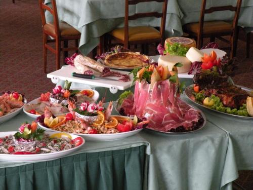 a table with many plates of food on it at Hotel Piccadilly in Lido di Camaiore