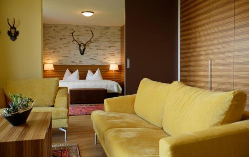 ein Wohnzimmer mit einem Sofa und einem Bett in der Unterkunft Schreiners Berghof in Hartberg
