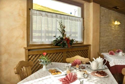 a dining room with two tables and a window at Hotel Garnì COSTANZA in Livigno