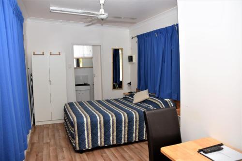 a bedroom with a bed and a desk at Chinchilla Motel in Chinchilla