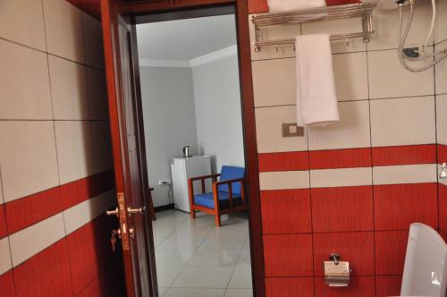 a bathroom with a toilet and a mirror at Kersay Hotel in Addis Ababa