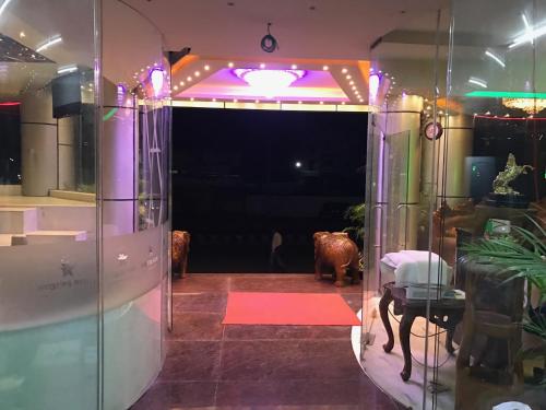 a room with a table and a purple light at Hyders Park The Business Hotel in Thanjāvūr