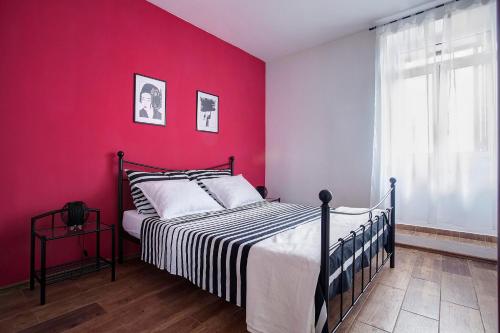 1 dormitorio con 1 cama con pared roja en Apartment Noa, en Šibenik