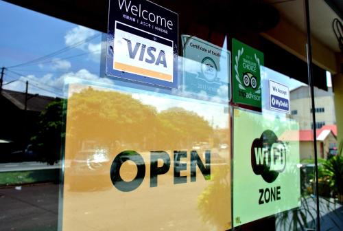 a sign that says open on a store window at Wau Hotel & Cafe in Jerantut