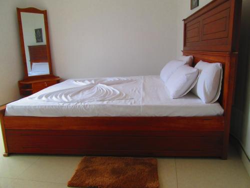 a bed with white sheets and pillows in a bedroom at Kandyan Sweet Villa in Kandy