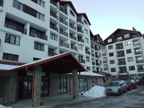 a large building with cars parked in front of it at Denitsa Apartment in Borovets
