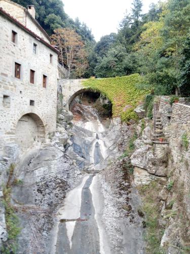 a stone bridge over a road next to a building at Borgo Iris in Pietraia