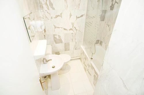 a bathroom with a sink, toilet and bathtub at Hôtel du Mont Blanc in Paris
