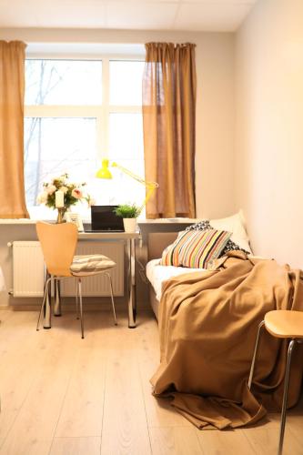 a bedroom with a bed and a desk and a window at Bridge Hotel in Rīga