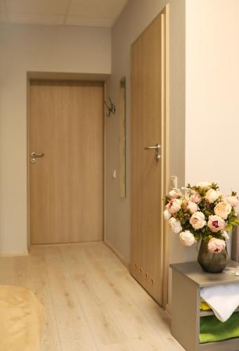 a room with a door and a vase of flowers at Bridge Hotel in Rīga
