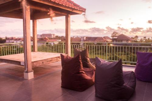 um grupo de almofadas sentado num alpendre com um gazebo em A7 Guesthouse em Canggu