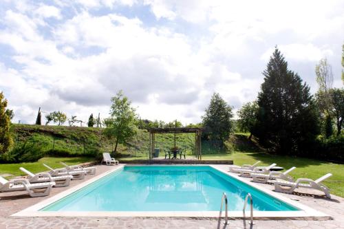 a swimming pool with lounge chairs and a table at Fattoria Casabianca in Bucine