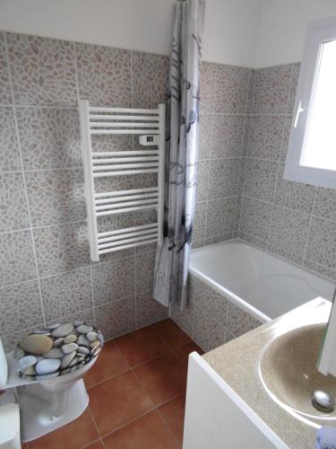 a bathroom with a tub and a toilet and a sink at Les Terrasses de Valensole in Valensole