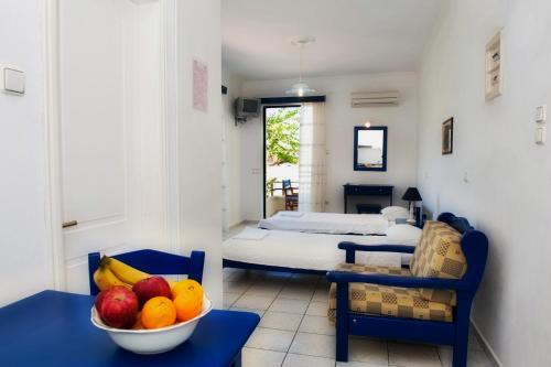 a room with a bed and a bowl of fruit on a table at Karfas Bay View in Karfas