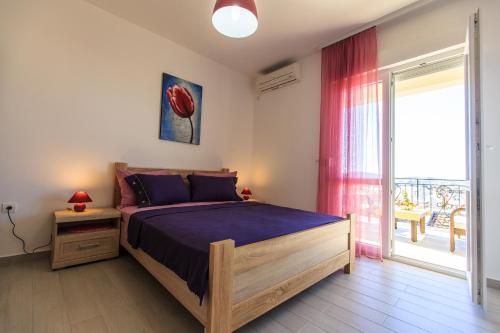 um quarto com uma cama e uma porta de vidro deslizante em Apartments Aleksić em Bar