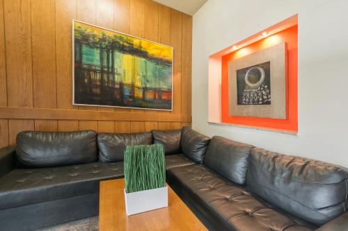a living room with a leather couch and a table at Hotel Lirak in Tetovo