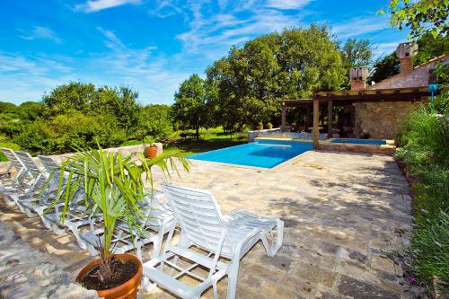 a row of white chairs next to a swimming pool at Villa Zamelinjak in Vrbnik