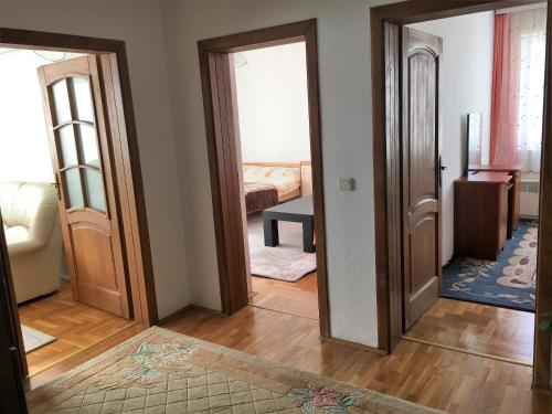 a hallway with two doors and a room with a bed at Center Apartment in Pristina