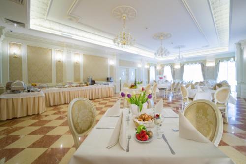 een grote feestzaal met witte tafels en stoelen bij Hotel Jarosław in Jarosław