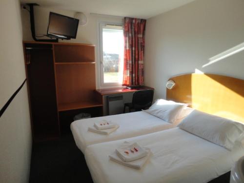 a hotel room with two beds and a window at Quick Palace Epinal in Épinal