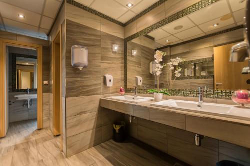 a bathroom with two sinks and a large mirror at Hotel Lirak in Tetovo