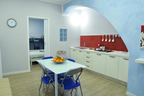 カステッランマーレ・デル・ゴルフォにあるCasa Tizianaのキッチン(テーブル、青い椅子付)
