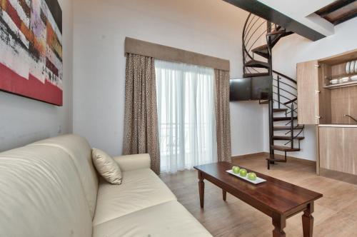 a living room with a white couch and a table at Palazzo Violetta in Sliema