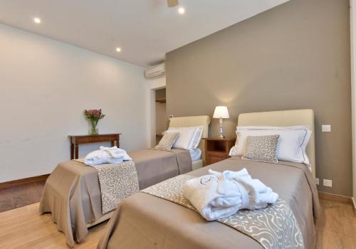 two beds with towels on them in a room at Palazzo Violetta in Sliema
