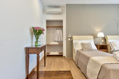 a bedroom with a bed and a table with flowers on it at Palazzo Violetta in Sliema